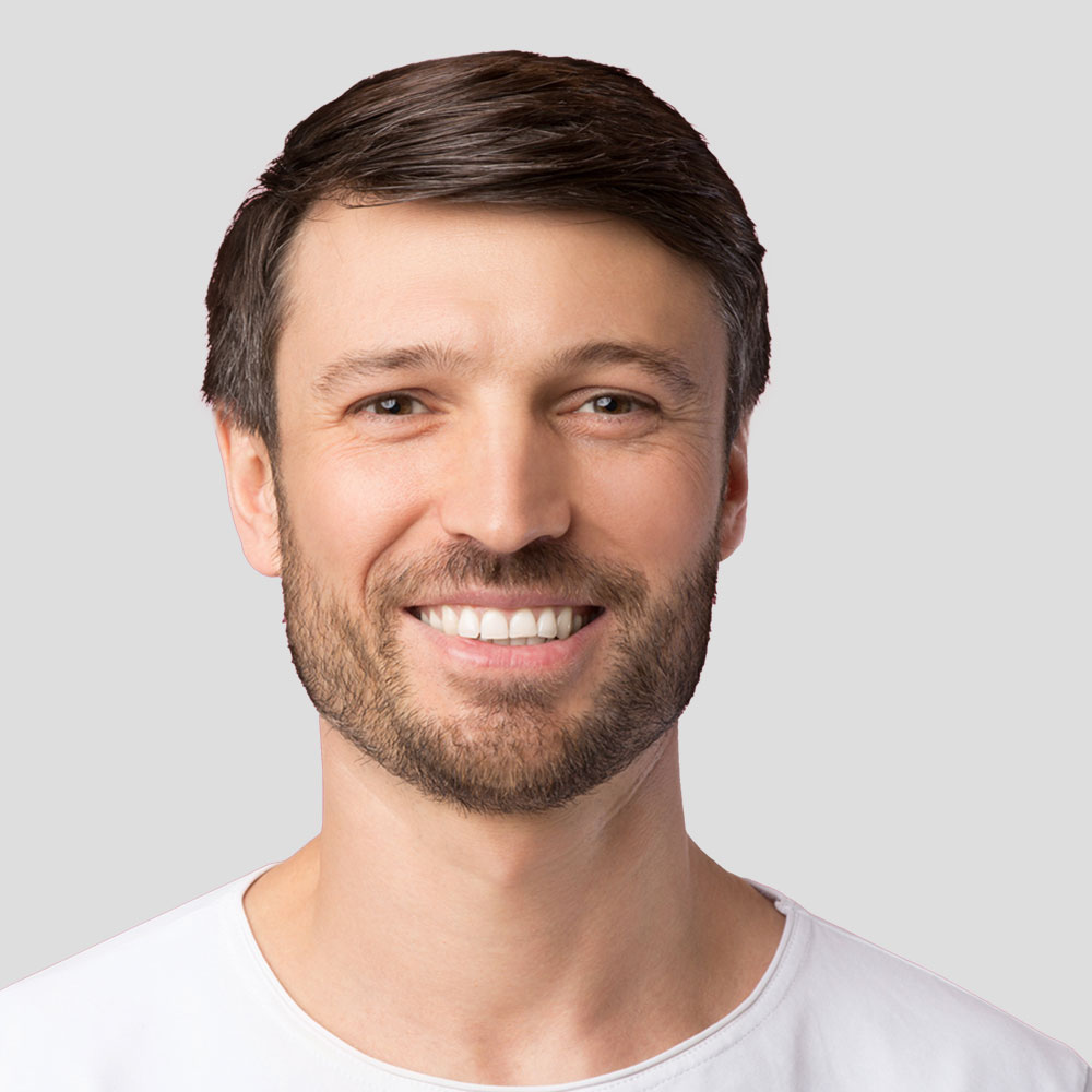 Homme barbu souriant face à l'objectif